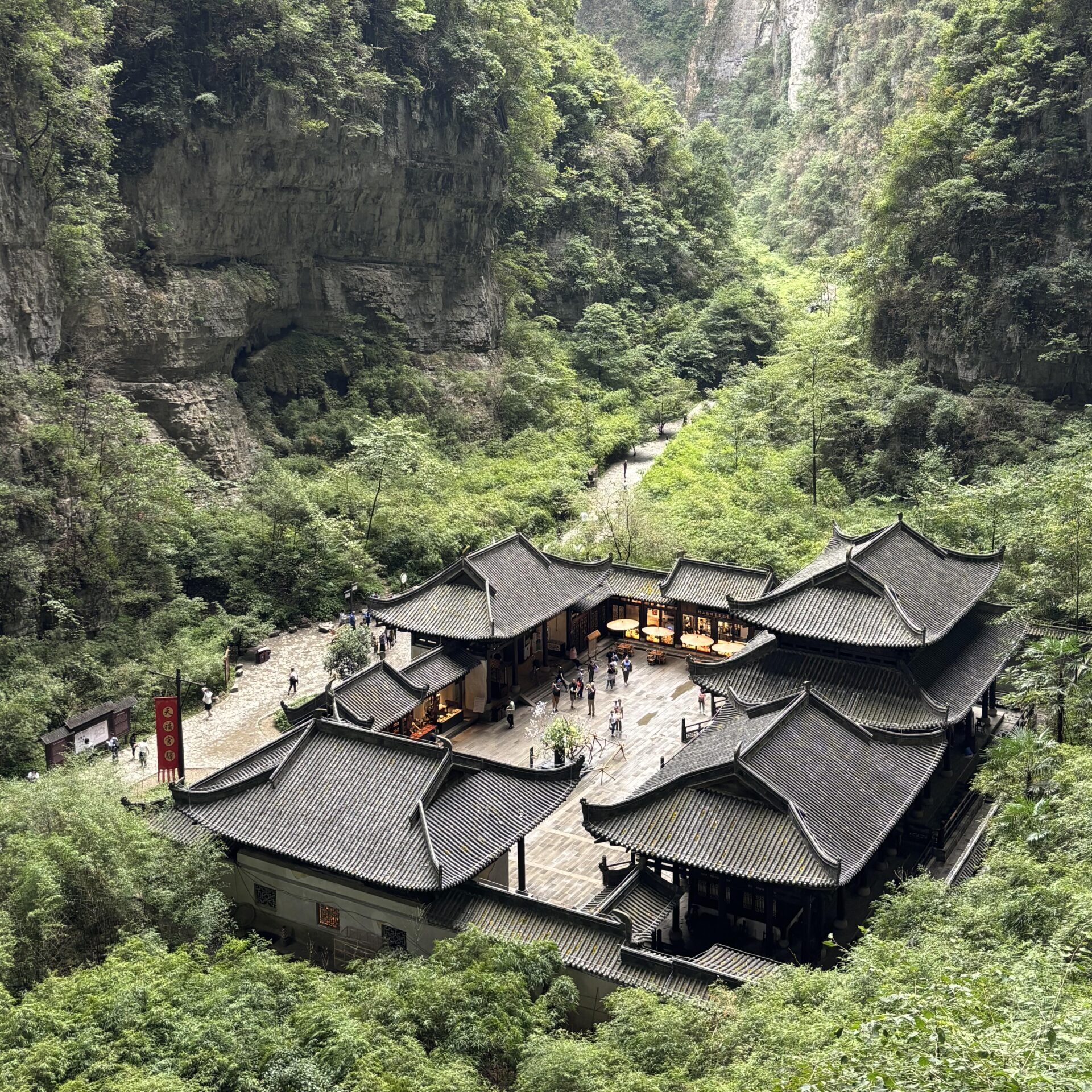 Traditional buildings surrounded by karst mountains in Wulong Three Natural Bridges scenic area